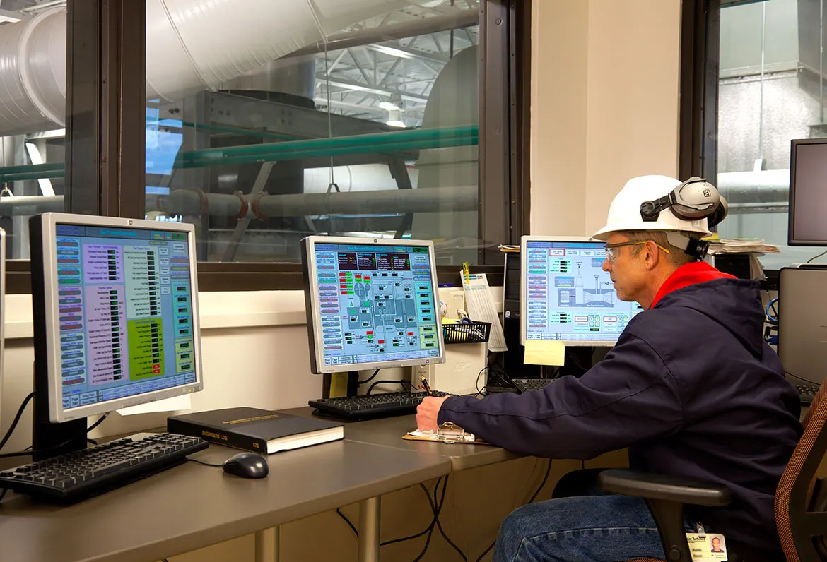 Engineers monitoring boiler performance screens.