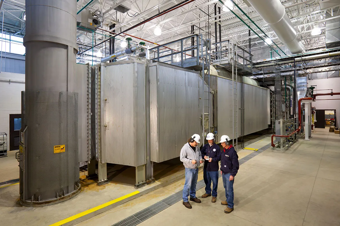 Engineers huddled to discuss the workings of the boilers behind them.