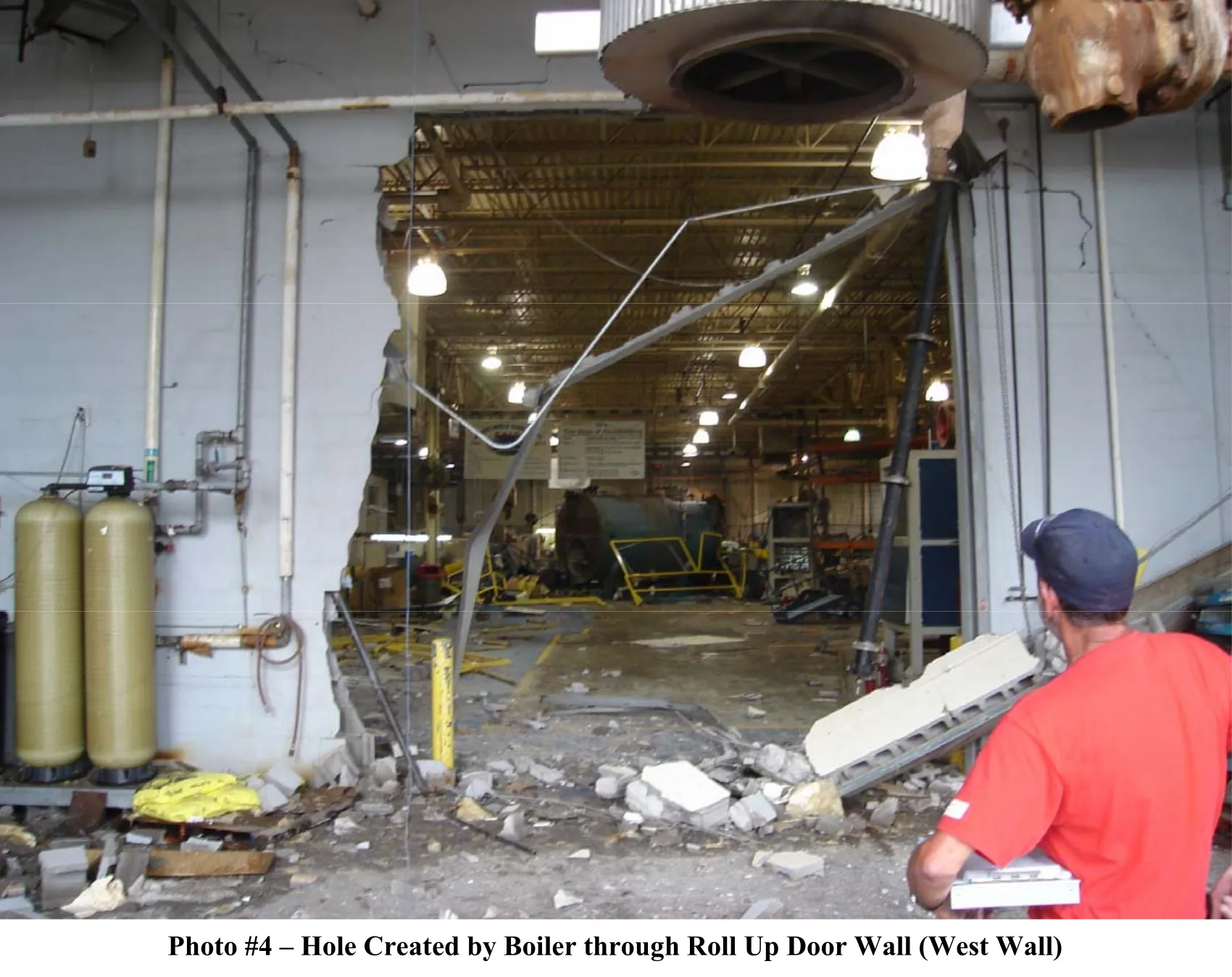photo 4 - facility wall where roll up door was with the boiler and ruined door in another part of the facility.